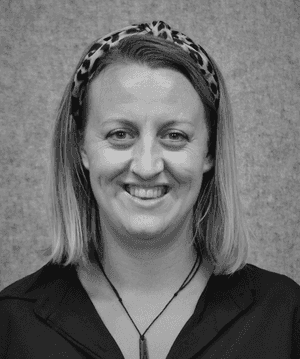 A black & white portrait of Stile team member Toni Cox smiling at the camera