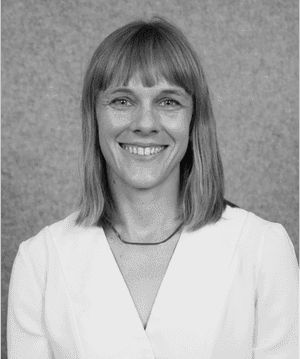 A black & white portrait of Stile team member Kat Gentry smiling at the camera